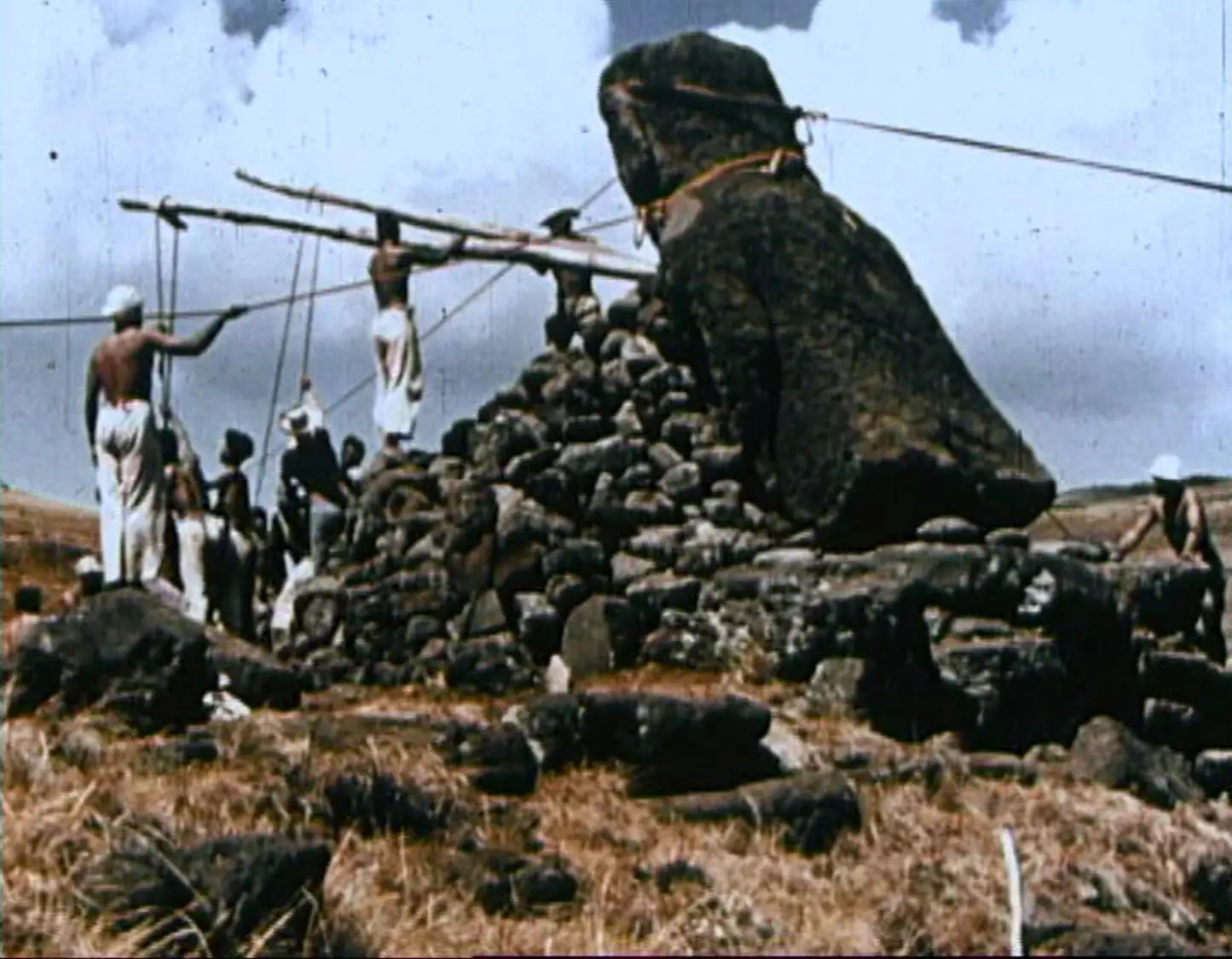 Una imagen histórica de la Isla de Pascua mostrando personas erigiendo una estatua Moai.