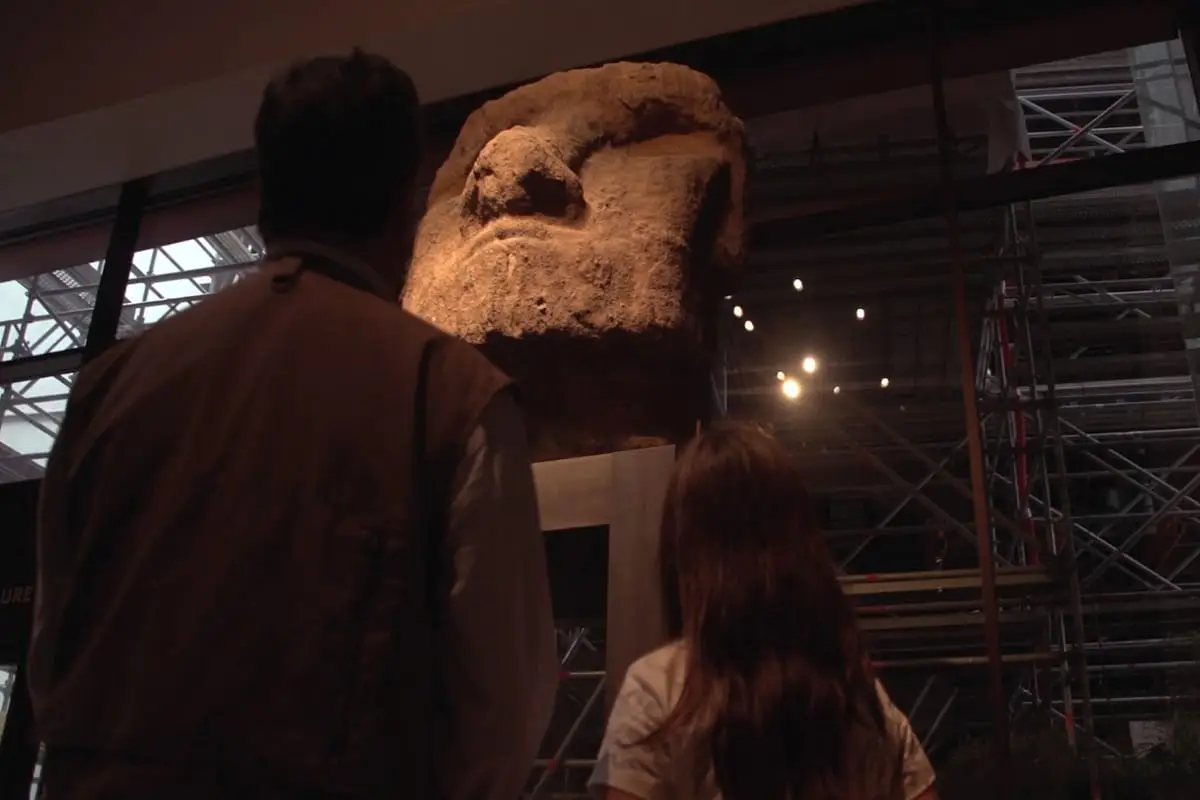 Cabeza de estatua Moai iluminada en un museo.